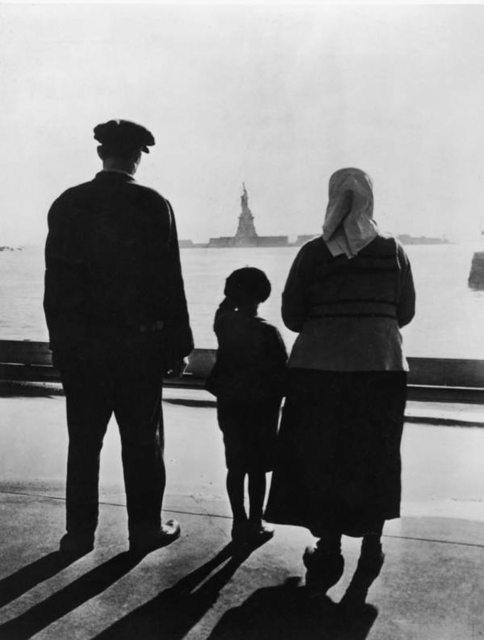 A family looking out at the Statue of Liberty from Ellis Island