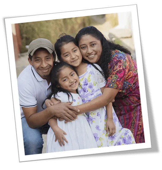 A smiling family of four embracing
